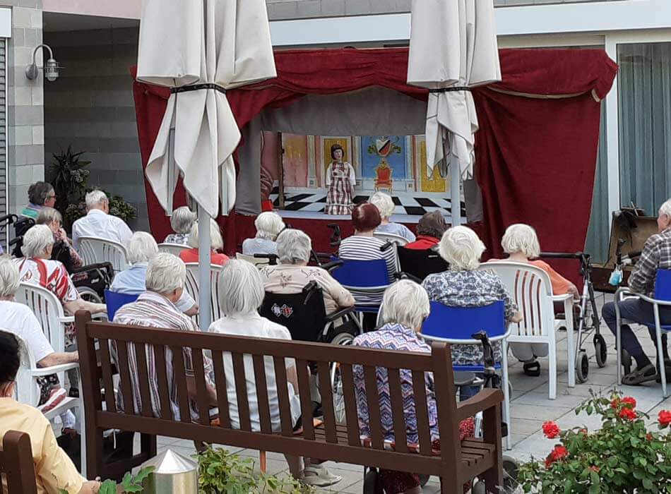 Senioren genießen Marionettentheater im Freien